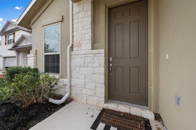 Property entrance featuring stone siding and stucco siding