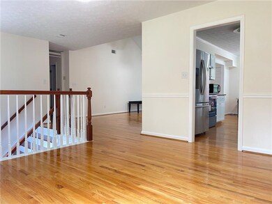 Empty room with light wood-type flooring, a textured ceiling, and baseboards