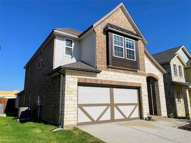 View of front of property featuring brick siding, a garage, driveway, a shingled roof, and stone siding