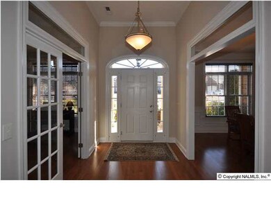 SPACIOUS FOYER ACCENTED WITH BEAUTIFUL HARDWOODS & MOULDINGS WELCOMES YOU HOME