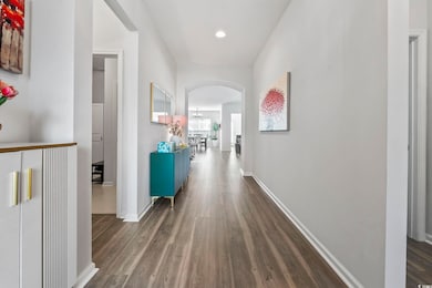 Hall featuring arched walkways, luxury vinyl flooring, and recessed lighting