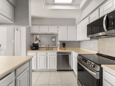 Kitchen featuring white cabinetry, stainless steel