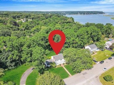 Drone / aerial view of a nearby body of water and a heavily wooded area
