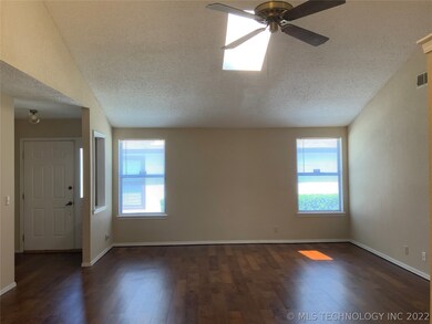 Living room with skylight and vaulted ceiling.