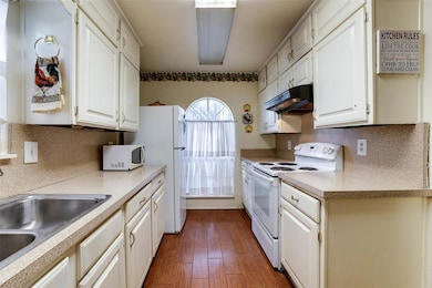 Kitchen with decorative backsplash, dark wood-type