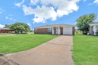 Ranch-style home featuring a garage, brick siding, concrete driveway, and a front lawn