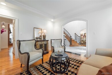 Hardwood floored living room featuring crown moldi