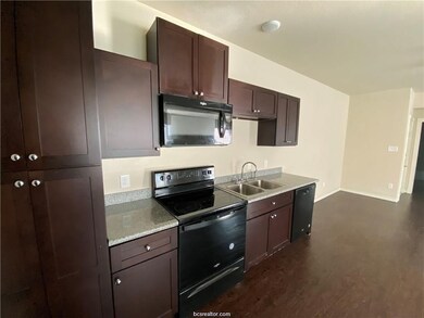 Kitchen featuring a sink, light countertops, dark