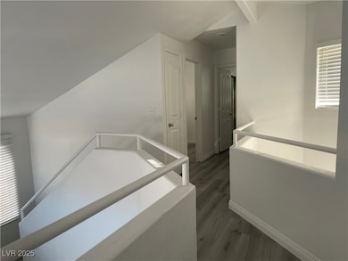 Hallway featuring lofted ceiling with beams, baseb