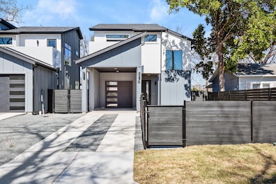 View of front of house featuring a garage, fence,