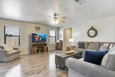 Living area featuring arched walkways, ceiling fa