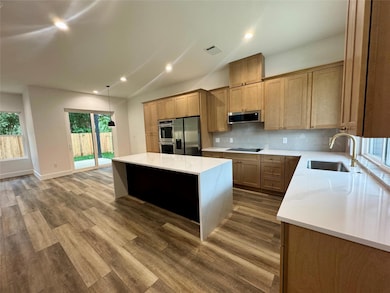 Kitchen featuring a sink, visible vents, backspla