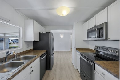 Kitchen featuring white cabinetry, stainless steel