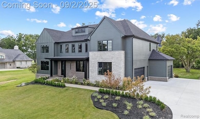 View of front of property with a front yard, driveway, roof with shingles, a garage, and board and batten siding