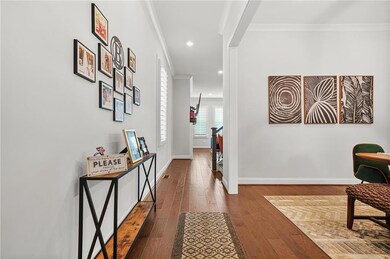 Hallway with crown molding, hardwood / wood-style flooring, baseboards, and recessed lighting