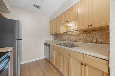 Kitchen with light brown cabinetry, a sink, stain