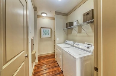Laundry area featuring dark wood-type flooring and