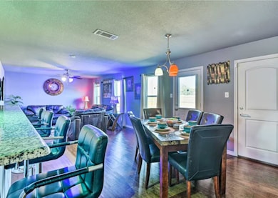 Dining space featuring a textured ceiling, dark wood finished floors, plenty of natural light, and ceiling fan