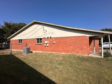 View of home's exterior with a lawn and brick siding