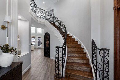 Stairs with baseboards, arched walkways, wood fini