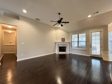 Unfurnished living room featuring a fireplace, dar
