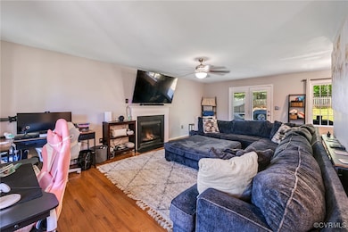 Living area with a ceiling fan, wood finished floo