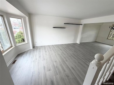 Unfurnished living room with light wood-type flooring and baseboards