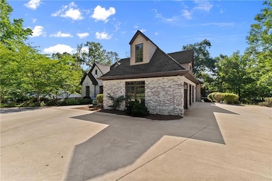 View of home's exterior with brick siding, concrete driveway, and a shingled roof