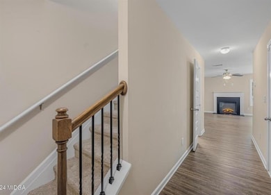 Corridor featuring dark wood-style flooring and baseboards