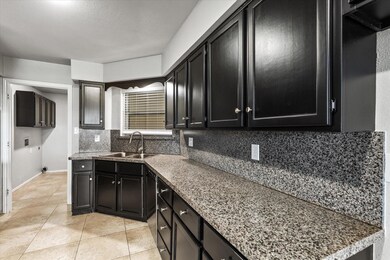Kitchen featuring sink, backsplash, and light tile