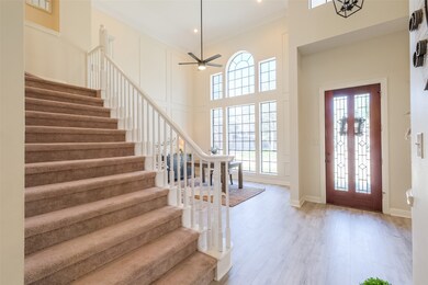 Front door view with a sitting room and extra wide staircase