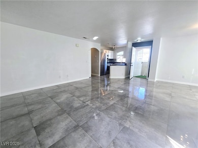 Unfurnished living room with arched walkways and b