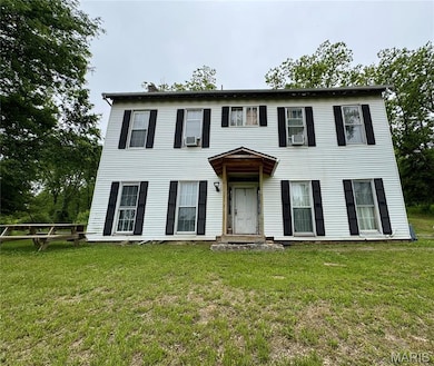 Colonial house featuring a front yard and cooling unit