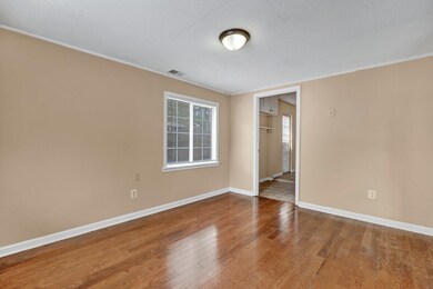 Empty room featuring a textured ceiling, hardwood 