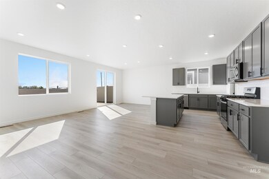 Kitchen with stainless steel appliances, a kitchen island, recessed lighting, light wood finished floors, and open floor plan