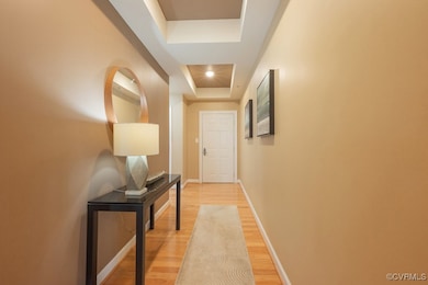 Hall featuring a tray ceiling, light wood finished