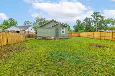 Back of house with a lawn, crawl space, entry steps, and a fenced backyard