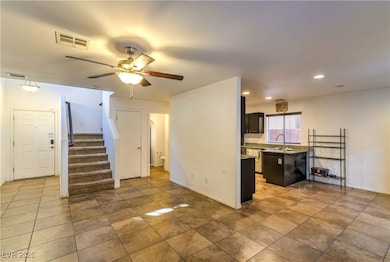 Unfurnished living room featuring stairway, a ceiling fan, recessed lighting, and light tile patterned flooring