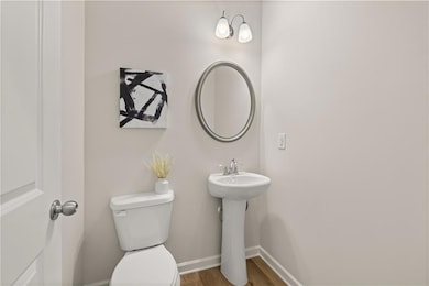 Bathroom with toilet, a sink, baseboards, and wood