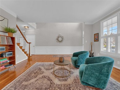 Living area featuring wood-type flooring and crown