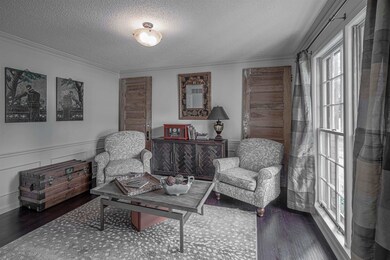 Sitting room featuring ornamental molding, dark ha