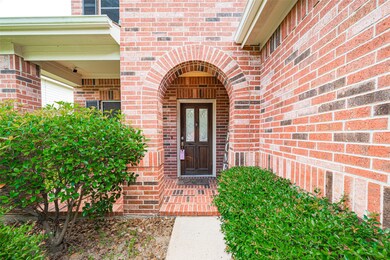 The inviting front porch is framed by greenery and