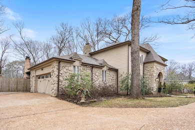 View of property exterior featuring driveway, ston