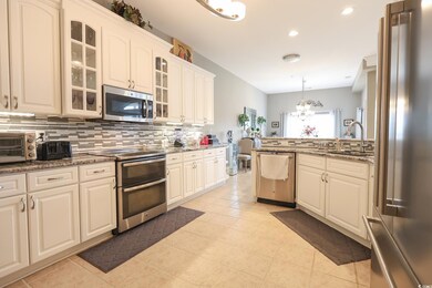 Kitchen featuring an inviting chandelier, backspla