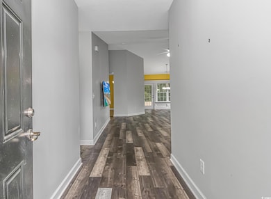 Corridor featuring lofted ceiling and dark wood-ty