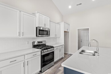 Kitchen with vaulted ceiling, appliances with stai