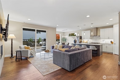 Large great room with high ceilings and grand chef's kitchen. Gas Fireplace, custom mounted TV, floor to ceiling tile surround.