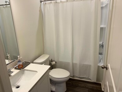 Bathroom featuring vanity, shower / bath combo, and wood finished floors