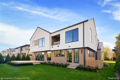 Rear view of property with a lawn and stucco siding
