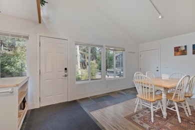 Dining area featuring high vaulted ceiling and rail lighting